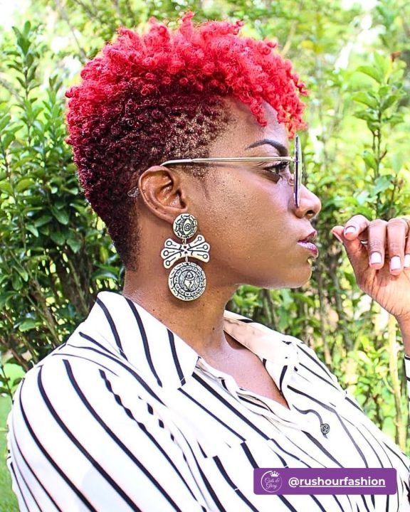 Cherry red coiled frohawk with dark tapered sides for a modern textured hair look.