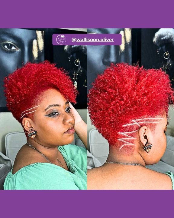 Vibrant cherry red curly afro tapered neatly down the sides, accented with a sharp razor-shaved zig-zag line carved into the fade.