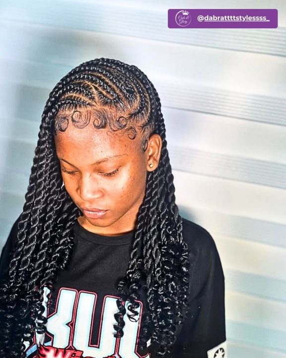 Jet black island twists styled in a side-swept lemonade look with curly ends.