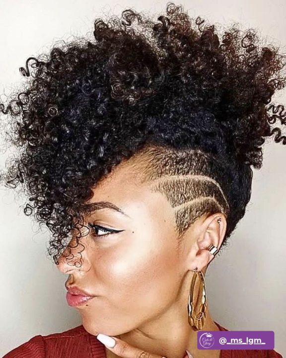 Natural black side-swept ringlet taper cut women's haircut featuring geometric undercut lines for short natural curly hair.