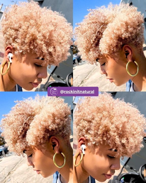 Striking platinum blonde coiled frohawk with defined natural texture running down the center, contrasted by clean tapered sides and a crisp nape line.