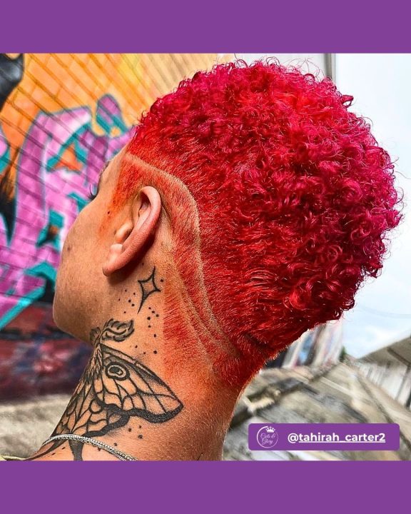 Vivid flame red coiled taper cut women's haircut featuring curved razor line art for short natural hair.