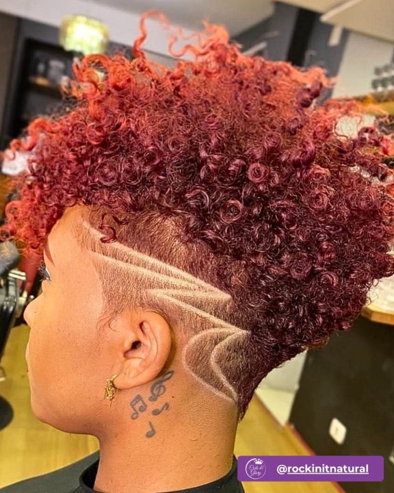 Wine red curly taper cut women's haircut featuring dual-curved side undercut line design for short natural hair.